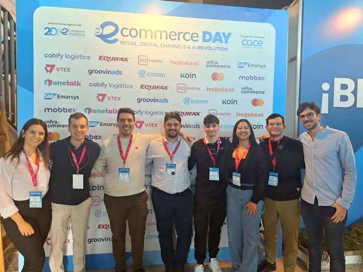 Integrantes del equipo de Caissa frente a la cartelería de eCommerce Day.