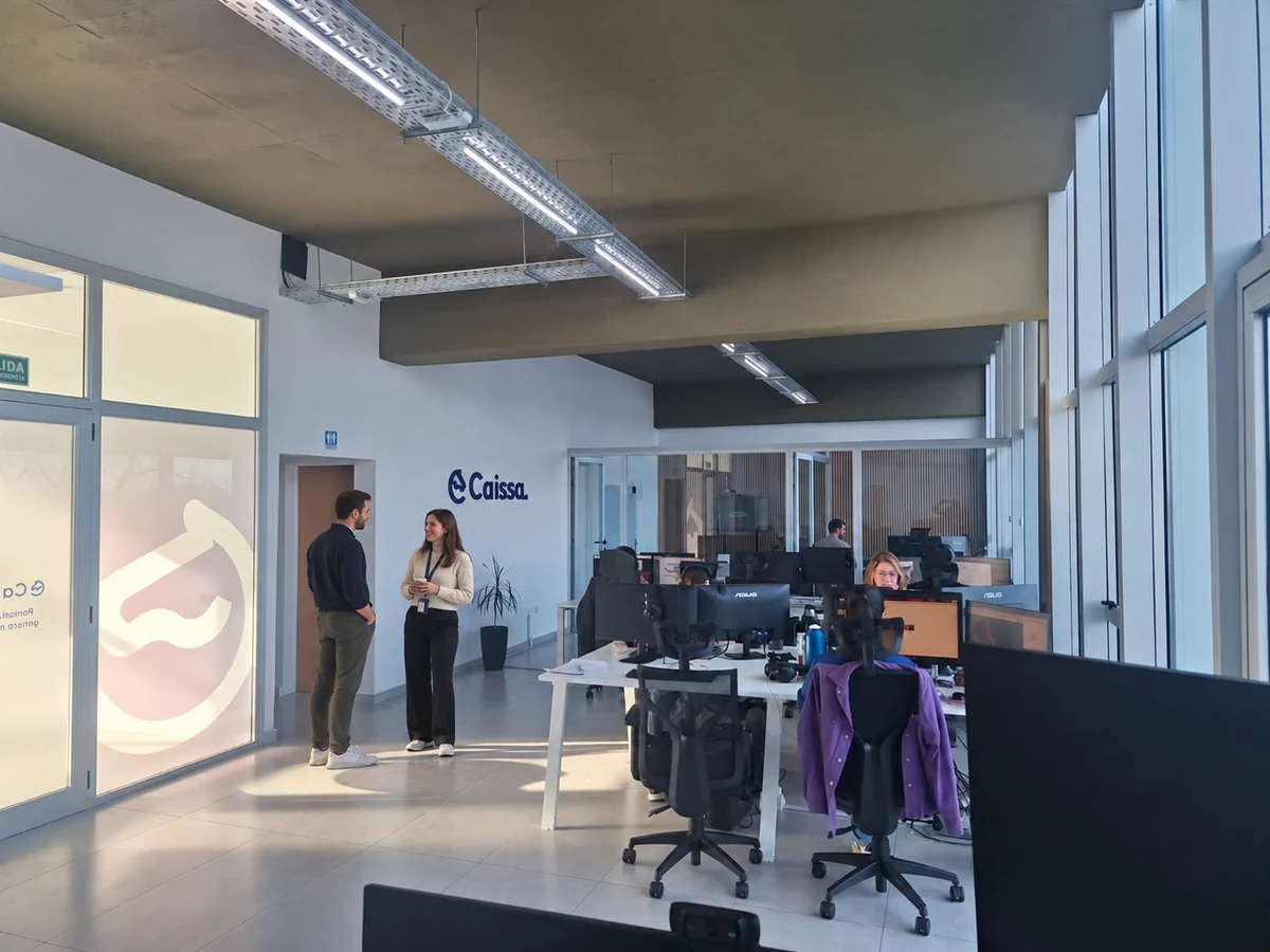 Oficina de Caissa en Neuquén Capital con personas en el área de trabajo.