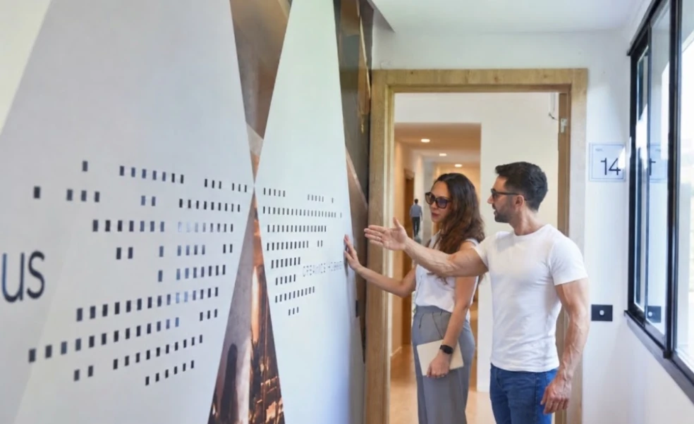 Dos visitantes observan un panel en uno de los espacios de IDEAR.