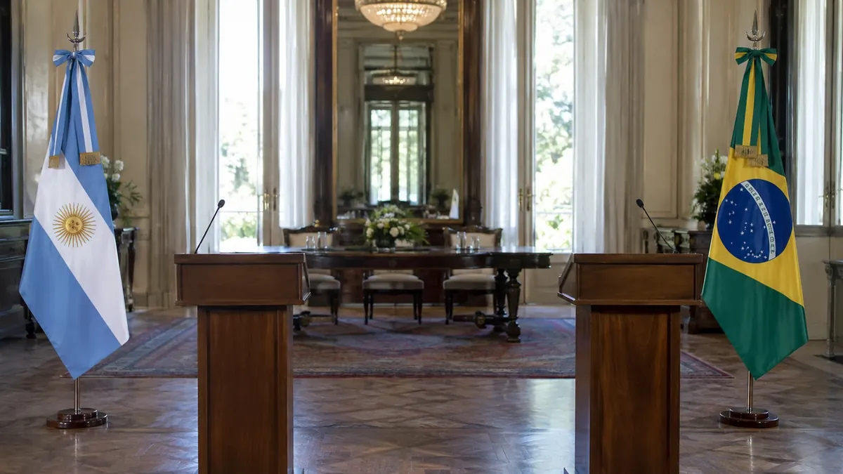Atriles vacíos junto a las banderas de Argentina y Brasil en una sala diplomática