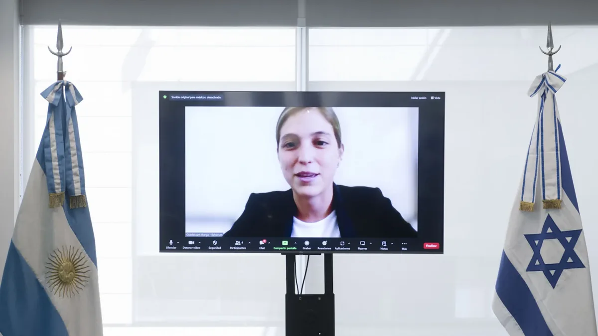 Guadalupe Murga en pantalla durante una videoconferencia entre las banderas argentina e israelí