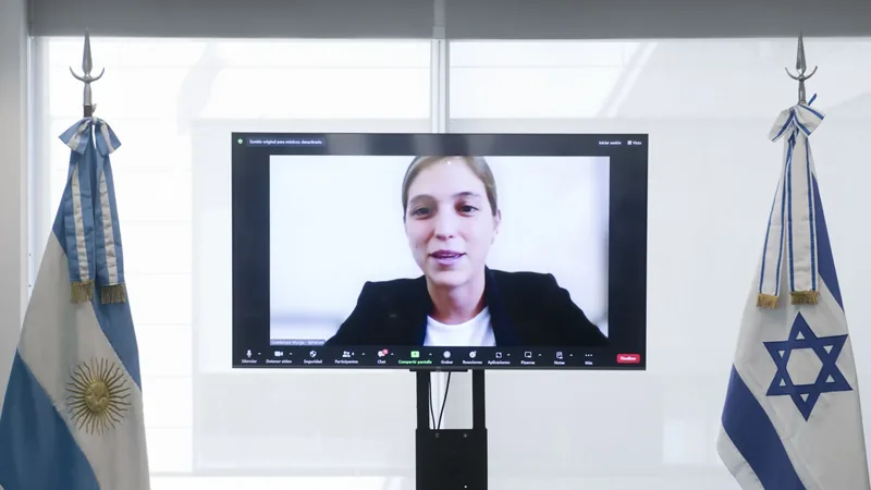 Emprendedora en pantalla durante una videoconferencia entre las banderas argentina e israelí